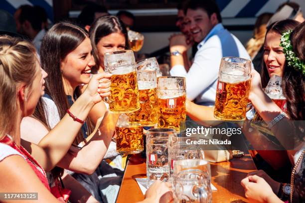 visitantes celebrando el oktoberfestfest en beer tent, múnich, alemania - bar de cerveza fotografías e imágenes de stock