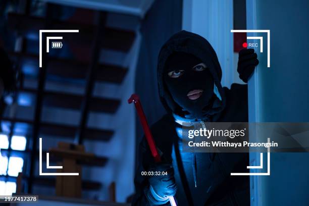 cctv view of burglar breaking in to home through window with crowbar - security camera view stock pictures, royalty-free photos & images