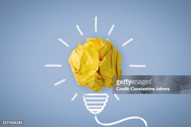 new idea. crumpled paper ball glowing bulb concept. - idee stock-fotos und bilder