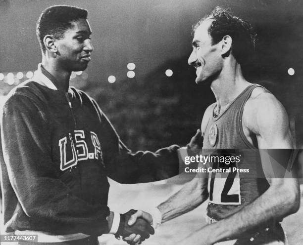 American high-jumper John Thomas congratulates Robert Shavlakadze of the Soviet Union on his victory in the Men's High Jump final at the Olympic...