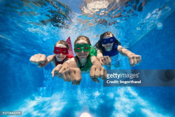 pequeños superhéroes volando bajo el agua - girl diving fotografías e imágenes de stock