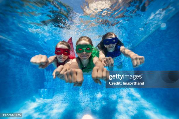 little superheroes flying underwater - child superman stock pictures, royalty-free photos & images