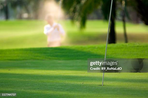 hitting golf ball from sand trap  into the hole - pga wedstrijd stockfoto's en -beelden