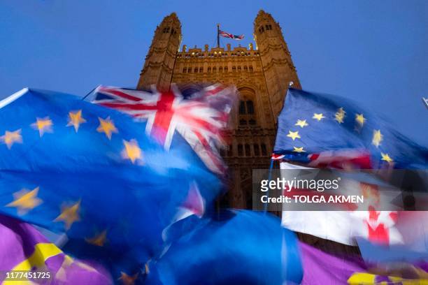 And Union flags flutter in the breeze as Pro and anti-Brexit demonstrators protest outside of the Houses of Parliament in central London on October...