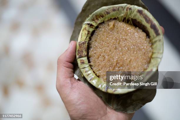 a sikh pilgrim holds prasad (a religious offering) at the golden temple (also known as sri harmandir sahib gurdwara) during the vaisakhi festival in amritsar, punjab, india - amritsar stock-fotos und bilder