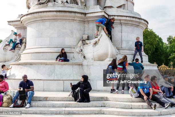 London, Buckingham Palace Victoria Memorial, monument with tourists.