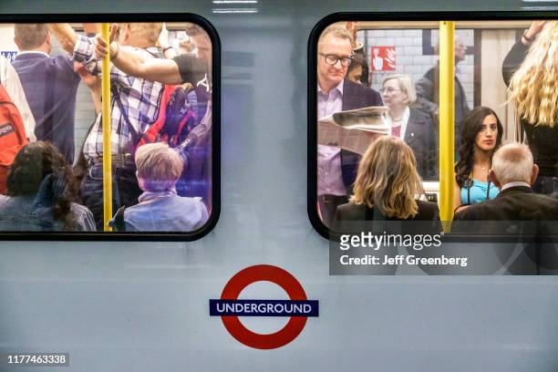 London, commuters in crowded subway car.