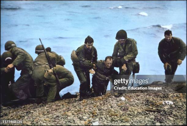 Soldiers of 116th Regiment of the 29th Infantry Division helped to shore Arriving at Omaha Beach in Life Raft after their Landing Craft Vehicle,...