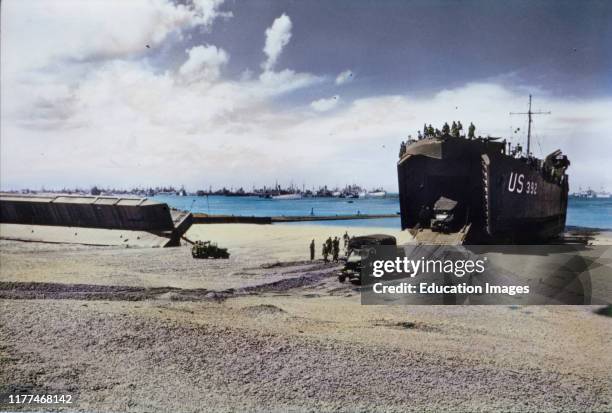 Trucks Exit From The Hold Of A US Naval LST on Beach After Storm Wrecked Artificial Mulberry Harbors, Normandy, France, June 1944.