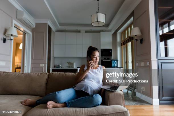 pregnant woman uses laptop at home - simple living room stock pictures, royalty-free photos & images