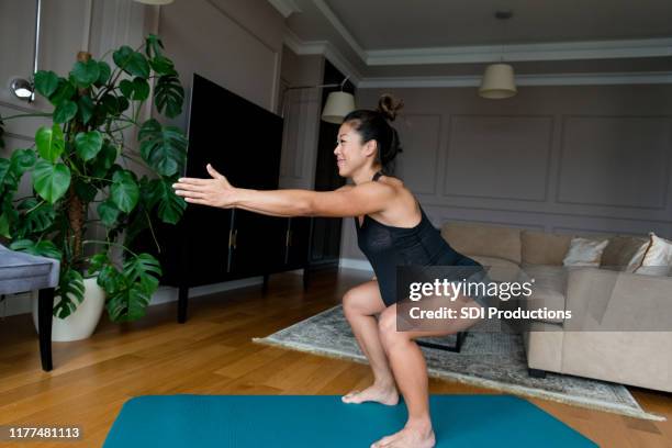 pregnant woman exercises in her home - pregnant home stock pictures, royalty-free photos & images