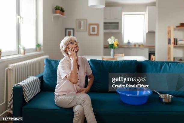 senior woman calling plumber for water leakage at home - flooded home stock pictures, royalty-free photos & images