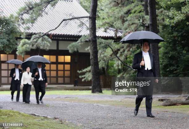 Japan's Prime Minister Shinzo Abe arrives at the Imperial Palace sanctuaries where Emperor Naruhito will report the proclamation of his ascension to...