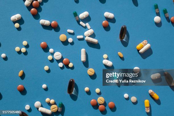 top view of various pills and tablets on the blue background - fish oil stockfoto's en -beelden