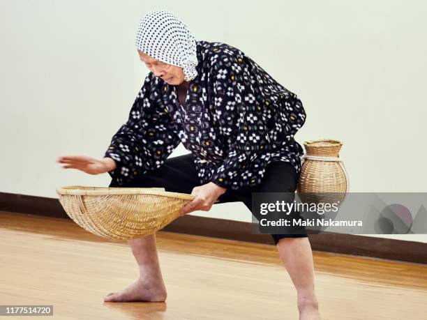 senior man imitating where he is taking a loach - 手ぬぐい ストックフォトと画像