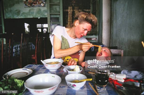 mother feeding her two year old son - pho stock pictures, royalty-free photos & images