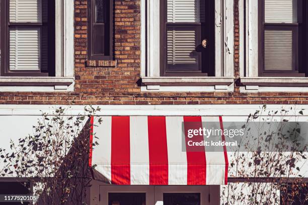 striped awning on brownstone in midtown manhattan - awning window fotografías e imágenes de stock