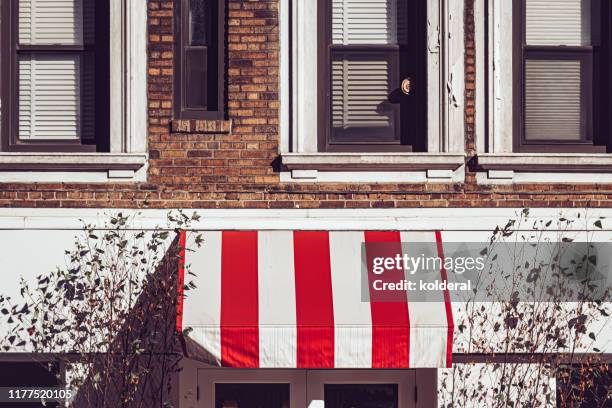 striped awning on brownstone in midtown manhattan - window awnings bildbanksfoton och bilder