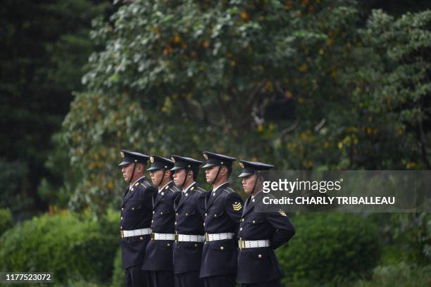 Japan Self-Defense Forces stand guard as they wait to fire artilleries to mark the proclamation of Japan's Emperor Naruhito's ascension to the...