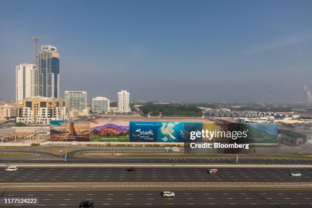 Motorists pass a giant billboard advertisement for the Saudi Arabian tourist board on Sheikh Zayed Road in Dubai, United Arab Emirates, on Friday,...