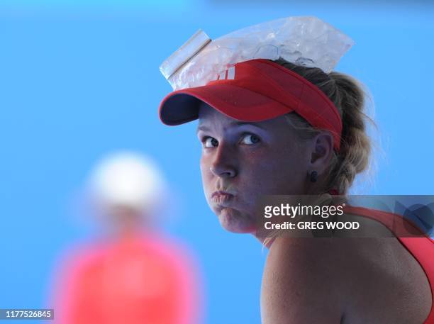Caroline Wozniacki of Denmark sits with an icepack on her head during a break against Anna Tatishvili of Georgia in their second round women's...