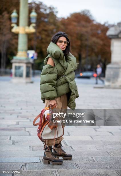 Victoria Barbara is seen wearing total look Loewe green asymmetric down feather jacket, beige pants, Louis Vuitton boots during Paris Fashion Week...