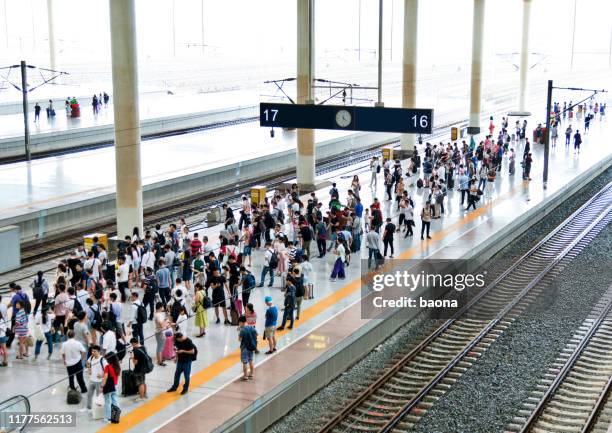 folla di passeggeri in attesa sulla banchina della stazione - binario di stazione ferroviaria foto e immagini stock
