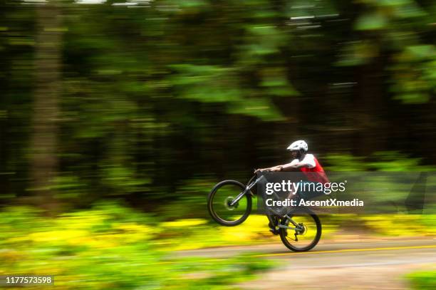 crosscountry mountainbiken in een weelderig bos - wheelie stockfoto's en -beelden