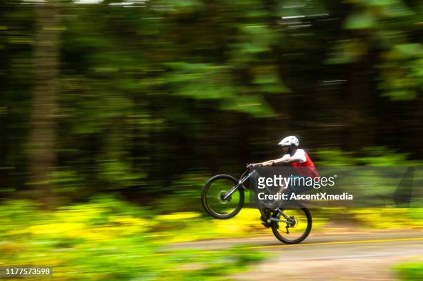 crosscountry mountain biking in a lush forest - wheelie stock pictures, royalty-free photos & images