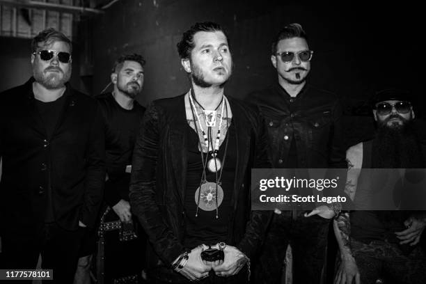 Dave Beste, Michael Miley, Jay Buchanan, Scott Holiday and Todd Ogren-Brooks of Rival Sons pose backstage at Michigan Lottery Amphitheatre on...