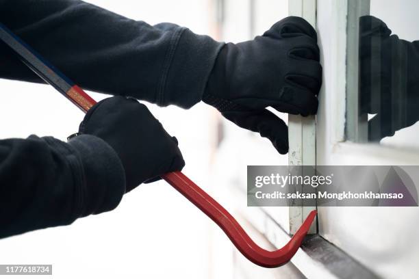 burglar trying to break into a house with a crowbar - cambrioleur photos et images de collection