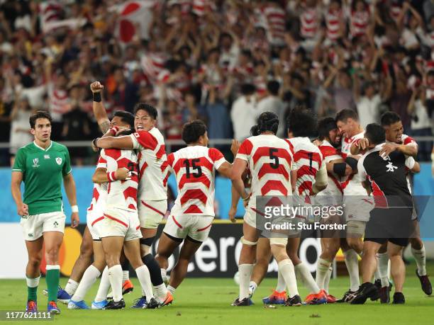 Ireland player Joey Carbery looks on as the Japan team celebrate victory on the final whistle after the Rugby World Cup 2019 Group A game between...