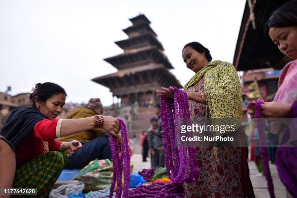 Woman buying amaranth flower garlands for the upcoming Tihar fetival at Bhaktapur, Nepal on Tuesday, October 22, 2019. Tihar mark as the festival of...