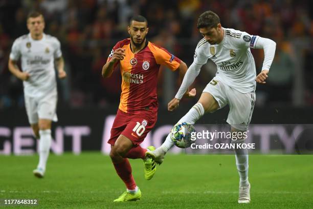 Real Madrid's Uruguayan midfielder Federico Valverde controls the ball in front of Galatasaray's Moroccan midfielder Younes Belhanda during the UEFA...