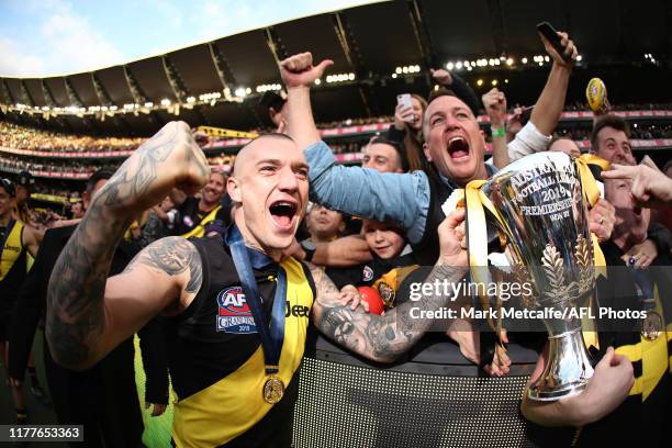 Dustin Martin of the Tigers celebrates victory with the Premiership Trophy and fans during the 2019 AFL Grand Final match between the Richmond Tigers...