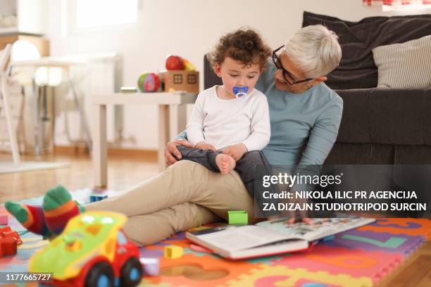 grand-mère jouant avec son petit-fils. - grandmas living room photos et images de collection