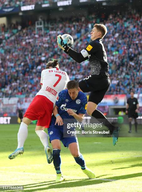 Alexander Nuebel of FC Schalke 04 catches the ball under pressure from Marcel Sabitzer of RB Leipzig during the Bundesliga match between RB Leipzig...