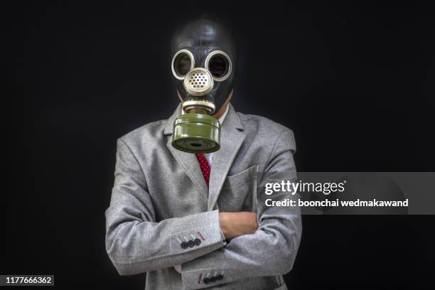 pollution concept: portrait of businessman in a gas mask. - traje nuclear fotografías e imágenes de stock