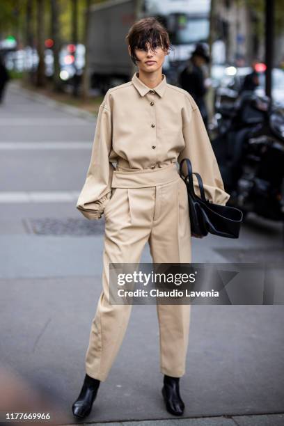 Model Giedre Dukauskaite, wearing a beige jumpsuit and black bag, is seen outside the Dries Van Noten show during Paris Fashion Week - Womenswear...