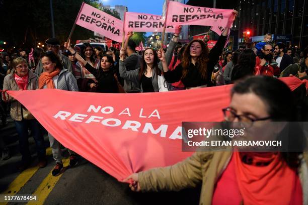 People demonstrate against a controversial security reform bill due to be voted in the upcoming October 27 general election, in Montevideo, on...