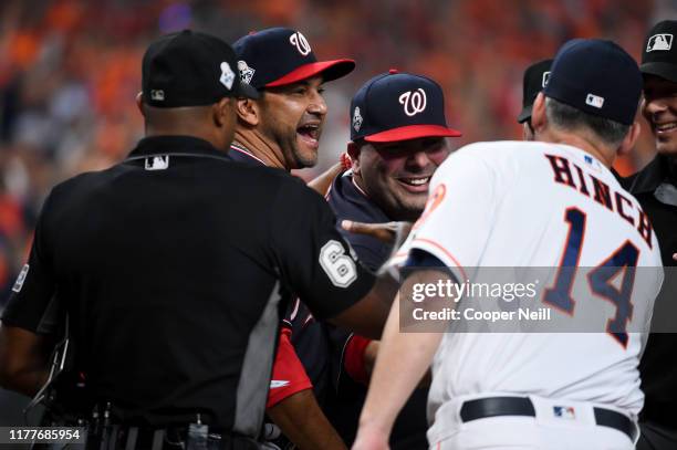Manager AJ Hinch of the Houston Astros shakes hands with batting practice pitcher Ali Modami and manager Dave Martinez of the Washington Nationals...