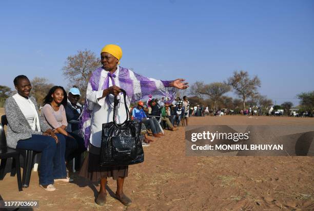 Woman talks to other voters while waiting in a queue to cast their vote at a polling station in Gaborone on October 23, 2019. - The general election...