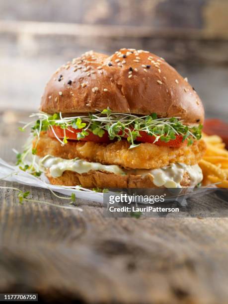 crispy fish burger with tarter sauce, micro greens, tomato on a brioche bun - alfalfa stock pictures, royalty-free photos & images