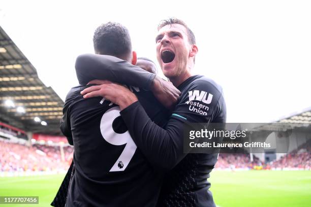 Andrew Robertson and Roberto Firmino of Liverpool congratuate Georginio Wijnaldum after scoring his team's first goal during the Premier League match...