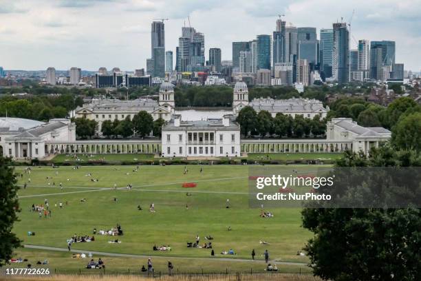 Canary Wharf as seen in epic cloudy panoramic view, Maritime Museum, Old Royal Naval College and London Skyline from Greenwich Park during the day in...