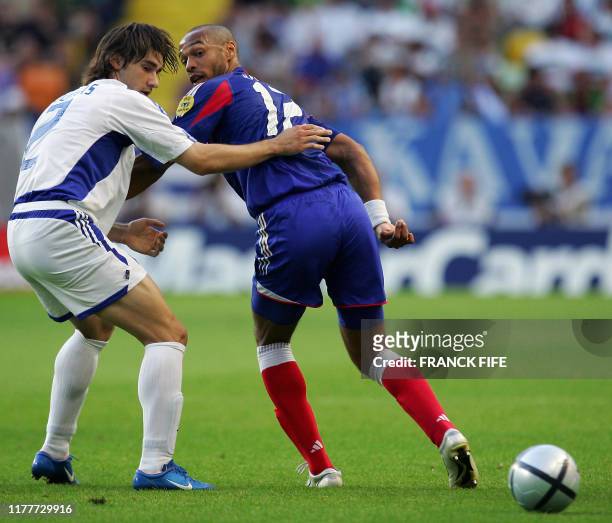 French forward Thierry Henry and Greece's defender Giourkas Seitaridis look at the ball, 25 June 2004 at Estadio Jose De Alvalade in Lisbon, during...