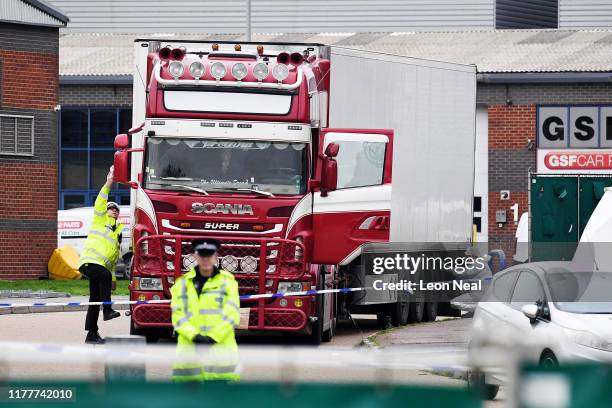 Police and forensic officers investigate a lorry in which 39 bodies were discovered in the trailer, as they prepare move the vehicle from the site on...