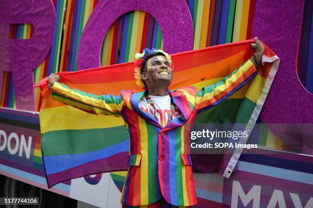 Colourful participant with a rainbow flag during the parade. The 50th Pride Parade toke place through Central London with over one million...