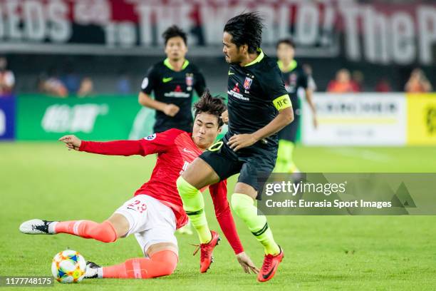 Shinzo Koroki of Urawa Red Diamonds fights for the ball with Park Ji-Soo of Guangzhou Evergrande during the AFC Champions League Semi Final second...