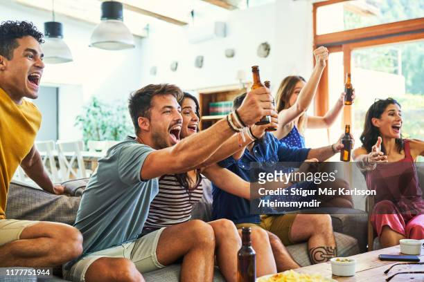 excited fans shouting while watching match on tv - match sport imagens e fotografias de stock